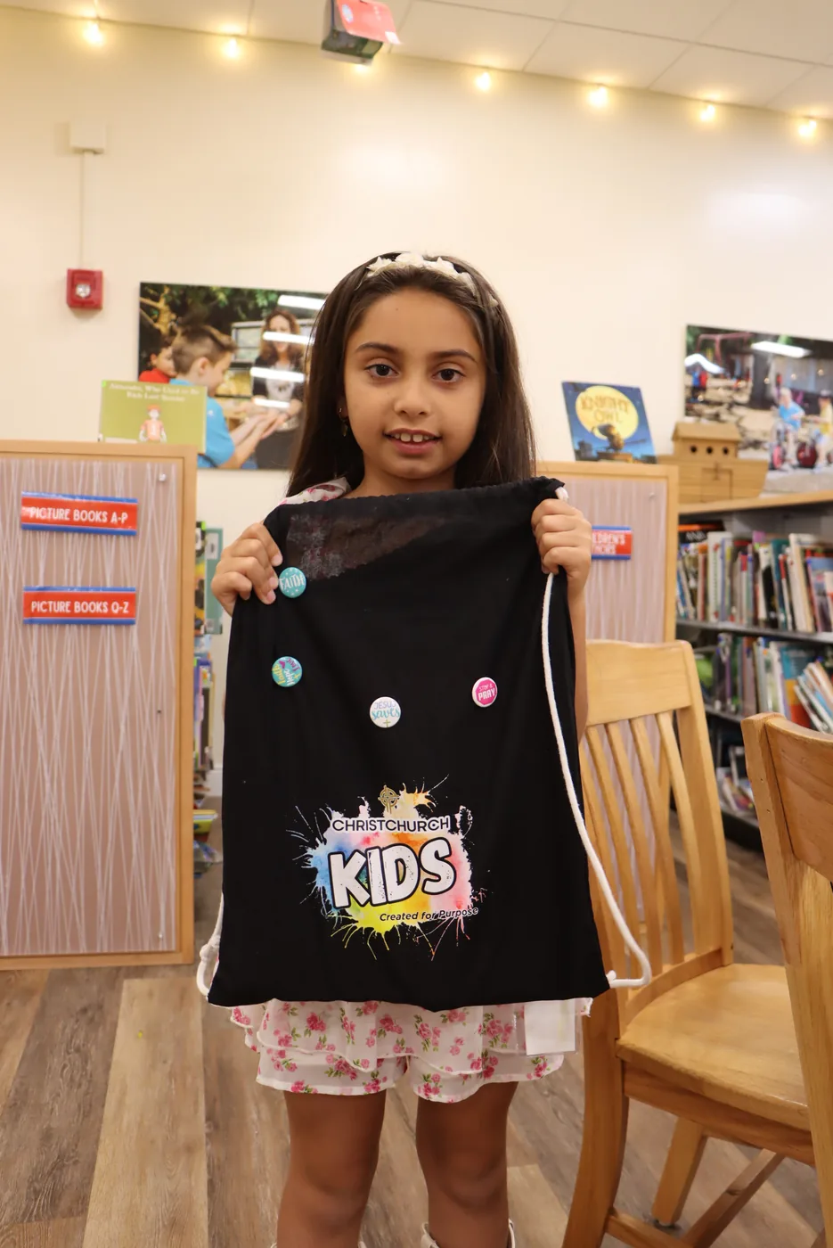 Una niña mostrando su bolsa de Christchurch Kids